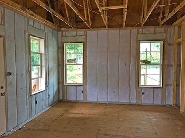 The 2-by-4 wall cavities are filled with R-15 of blown fiberglass insulation, which combines with the R-10 exterior rigid foam to provide a continuous thermal blanket of R-25.