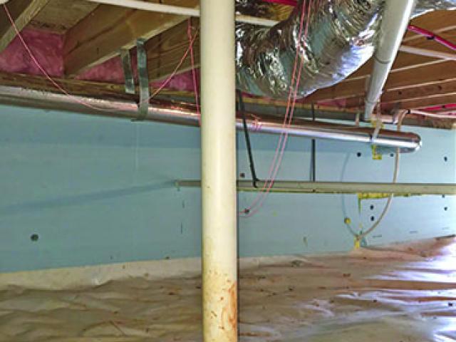 The unvented crawlspace is insulated along the interior of the concrete block walls with rigid foam, while the crawlspace floor is covered with heavy visquene and outfitted with a passive radon venting stack to keep soil gases from accumulating in the home.