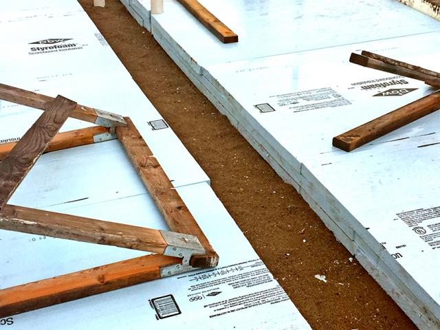 Six inches of rigid foam insulation under the slab and ICF foundation walls wrap the slab in a continuous thermal blanket.