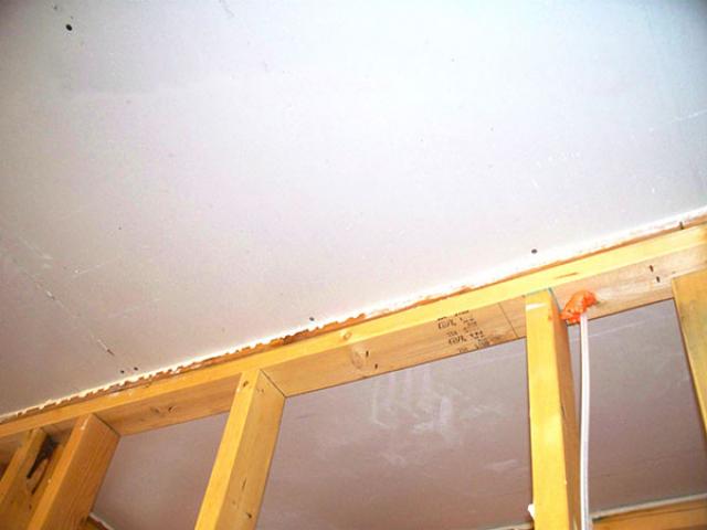 Draft-free construction includes sealing the ceiling drywall to the top plates with latex spray foam. Knaggs' crews also seal seams in the plastic vapor barrier before pouring the foundation slab, at the slab-to-foundation wall seams, at the wall-to-bottom plate seams, and at the plywood sheathing corners and top plate seams.