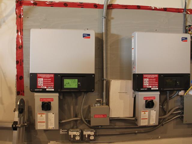 These inverters convert the direct current electricity produced by the solar electric system to alternating current. The house is wired with emergency circuits that tie into the inverters for power, refrigeration, and lighting during utility power outages.