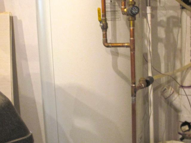 A centrally located 80-gallon storage tank holds hot water from the air-to-water heat pump.