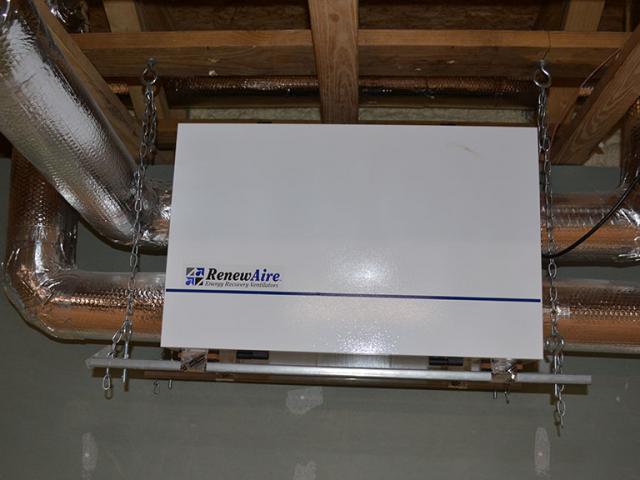 The home's fresh air system consists of an energy recovery ventilator that pulls fresh air in through a filter while exhausting stale air to the outside. The two air streams pass through a heat exchanger where heat from the warmer stream is passed to the cool air stream, helping to keep warmth in the home in winter and out of the home in summer.