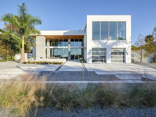 Concrete and pervious stone replace lawn for minimal water use and low-maintenance landscaping.