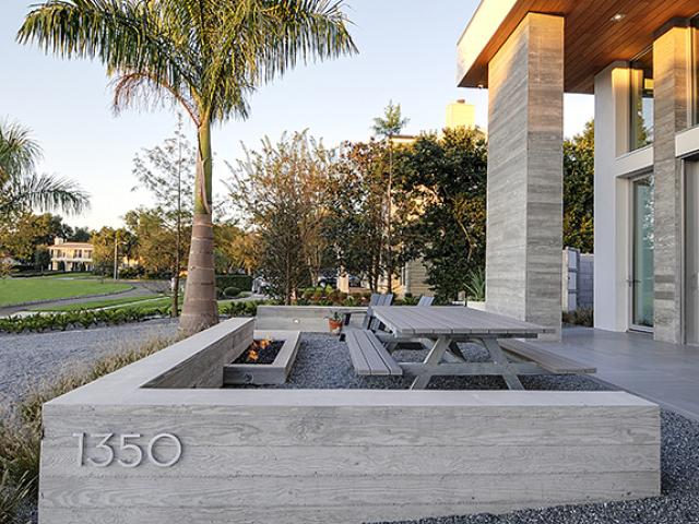 Durable concrete walls, thermoplastic polyolefin (TPO) roofing, protective overhangs, and pervious stone ground cover all increase the home’s resistance to tropical storms.