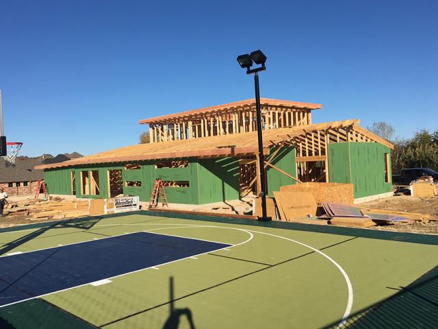 The coated OSB sheathing is covered with house wrap under the fiber cement siding, and then with an additional layer of felt paper under the cultured stone for triple protection against wind-blown rain.