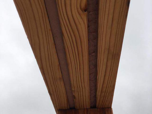 Rigid foam is sandwiched between layers of lumber to provide a thermal break in the walls above doors and windows.