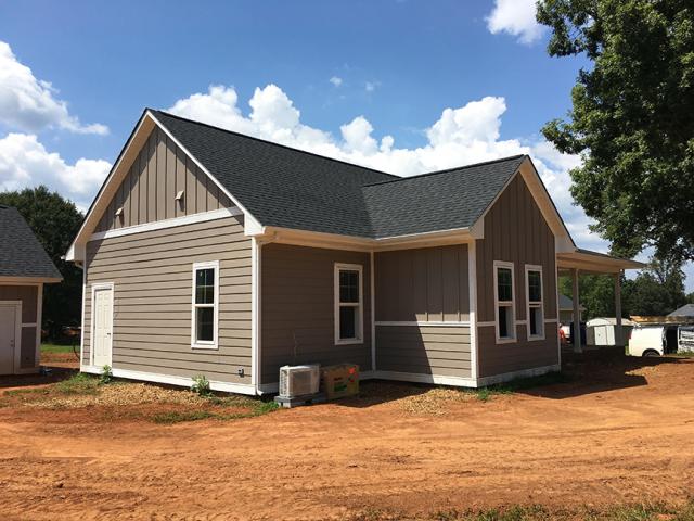 Architectural 30-year shingles cover coated OSB roof decking on the simple gable roofs, which are steep pitched to encourage drainage in the humid climate.