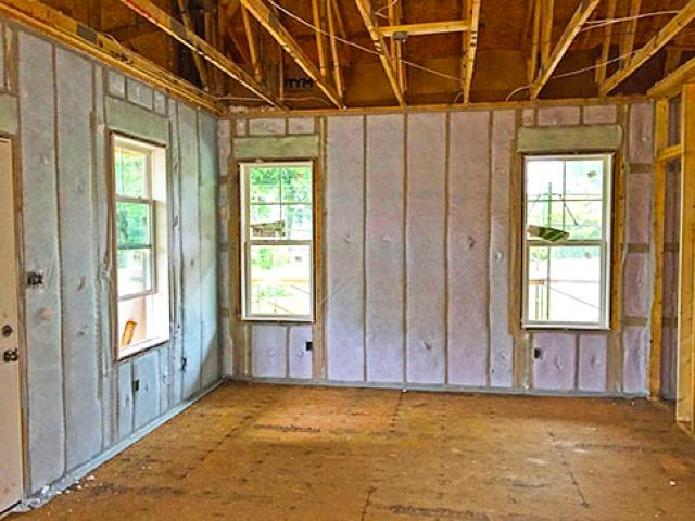 The 2-by-4 walls exterior walls were constructed with advanced framing details including insulated corners, insulated headers, and ladder blocking for insulated intersections that left more room for the R-15 blown-in fiberglass cavity insulation. The exterior was sheathed with OSB then covered with R-10 EPS rigid foam with taped seams.