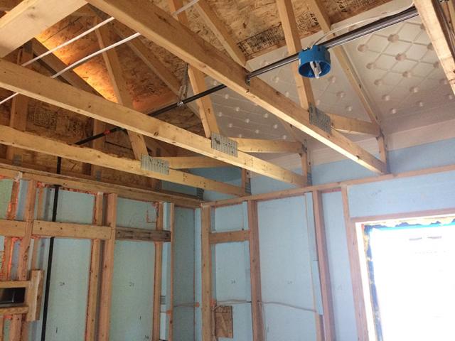 The 2-by-6, 24-inch on-center walls of the home are sheathed with 2 inches (R-10) of rigid foam. An additional 2 inches of foam is installed between the studs. Plywood is used only at the corners for wind bracing. Baffles will carry air from soffit vents to ridge vents to help keep the attic dry.