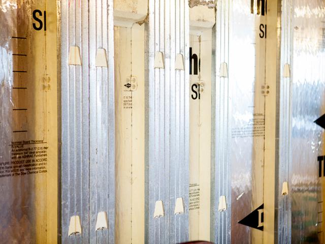 The basement walls consist of pre-cast reinforced concrete wall panels that arrive at the site with a 2.5-inch layer of XPS rigid foam adhered to the wall panels and 1-inch layers of rigid foam attached to each side of the rebar-reinforced concrete studs, which are faced with a galvanized steel nailing surface.