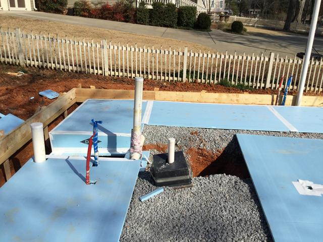 A layer of R-5 rigid foam was laid on the crushed rock before pouring the basement and grade-level slabs.