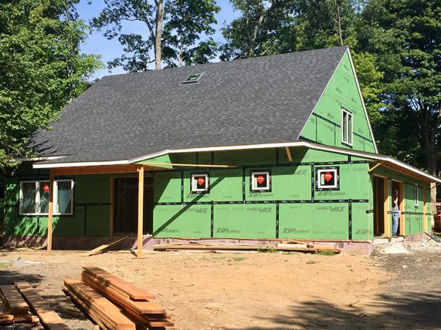 The coated insulated sheathing is taped at all seams to serve as both an air barrier and weather-resistant barrier.