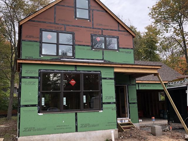 The home is sheathed with a coated OSB product. When the seams are taped, this sheathing takes the place of house wrap to serve as a weather-resistant barrier and air barrier.