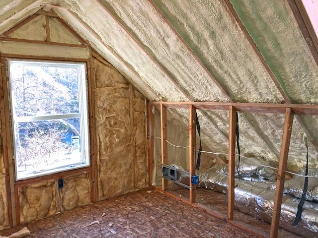 The unvented attic is insulated along the underside of the roof deck with 7 inches (R-49) of closed-cell spray foam, providing vaulted ceilings and a conditioned knee wall space for ducting. The advance framed 2-by-6, 24-inch on-center framed walls are filled with 2 inches of closed-cell spray foam plus 3.5 inches of fiberglass batt for an R-27 total.