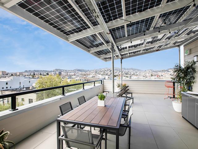 Photovoltaic panels make up the roof of this rooftop deck, providing roofing that generates electricity while providing waterproof shading that lets 15% of the light through to brighten the space below.
