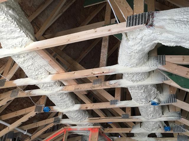 HVAC ducts for the high-efficiency natural gas furnaces were encapsulated in 3 inches of closed-cell spray foam, then buried in R-49 of blown fiberglass insulation in the vented attics.