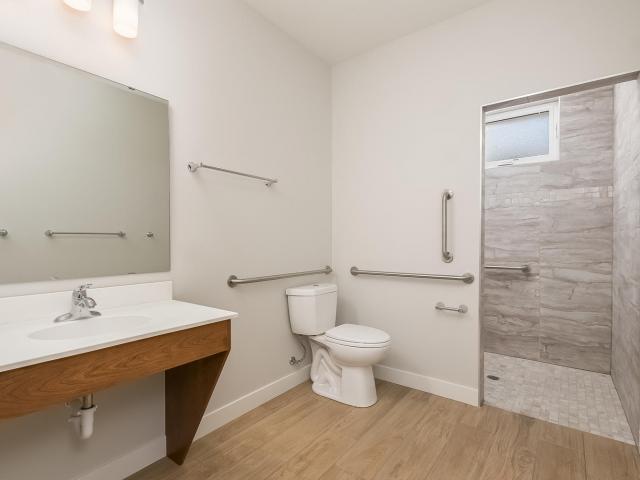 The home is handicap-accessible, with a no-step front entry, wider hallways and 3-foot doors, lever-style door handles, a full ADA main-level bathroom, zero barrier showers on both main-level bathrooms, and a lowered kitchen eat-in island. Mid-chord bearing trusses allow for future ramp access from the garage to the house.