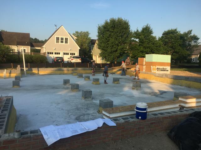 After building the CMU crawlspace foundation wall, the builder sprayed 2 inches of closed-cell spray foam on the ground and half way up the sides of the stem walls and piers. Then he installed a SIP rim band, the floor joists and the first-floor decking and mechanicals, then he came back and sprayed from the subfloor down over the SIP band and overlapping the initial spray. This provided a continuous R-15 insulated crawlspace with R-30 at the bands.