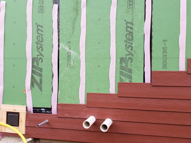 Strips of flexible foam provide a ventilating air gap between the R-6.6-insulated coated sheathing and the fiber cement lap siding.