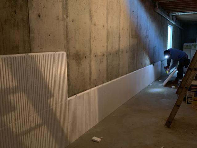A continuous layer of rigid foam insulates the interior surface of the insulated basement while spray foam fills the band joists to continue the thermal protection.