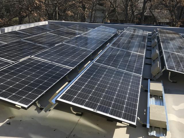 A 12-kW array of solar panels is installed on angled racks on a flat roof of the home. The home also has two solar batteries with a capacity of 13.5 kWh each, or 27 kWh total.