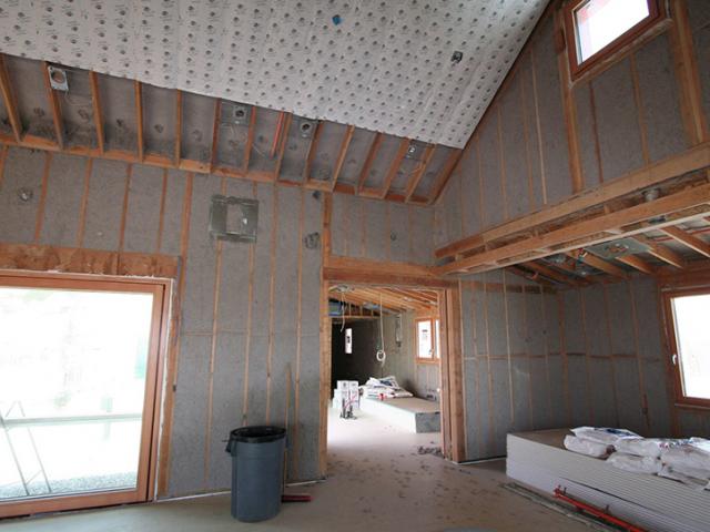 The 2-by-6 double-stud advance-framed walls are stuffed with R-56 of blown cellulose. Sheets of phase-change material are installed over the cellulose to help even out interior temperatures in this high-desert location.
