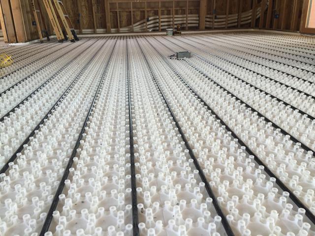 The roof-mounted solar thermal panels and an air-to-water heat pump provide hot water for the home's radiant floor heating system.