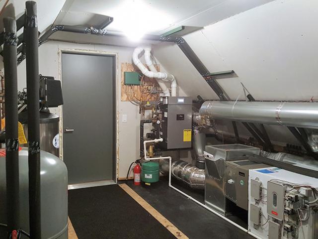 The utility room houses the home's high-efficiency gas boiler, which supplies hot water for the floor heating system and faucets, as well as the home's central air source heat pump and energy recovery ventilator fresh air system.