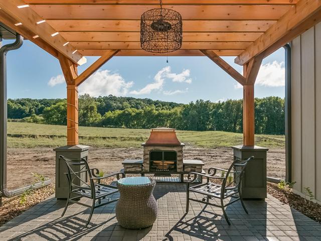 A sheltered patio provides a cool inviting outdoor retreat. The patio is surfaced with pavers to reduce the amount of impervious surfaces around the home.