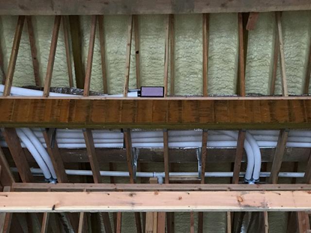 The attic is wrapped in a 3-inch blanket of closed-cell foam sprayed on the underside of the roof deck. The rafter bays were further filled with high-density fiberglass batts.