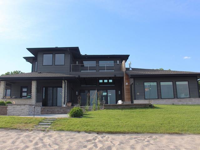The home's design includes deep overhangs and covered porches that protect the walls and windows from high summer sun.