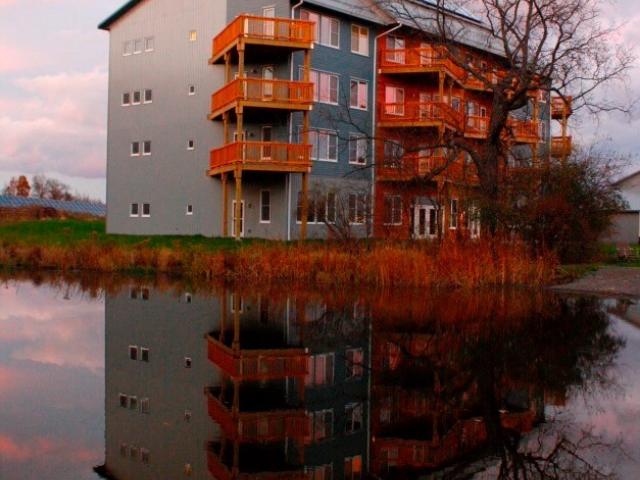 This multifamily structure is part of EcoVillage at Ithaca, a community of energy-efficient multifamily, duplex, and single-family homes built around shared community gardens, open spaces, and ponds.