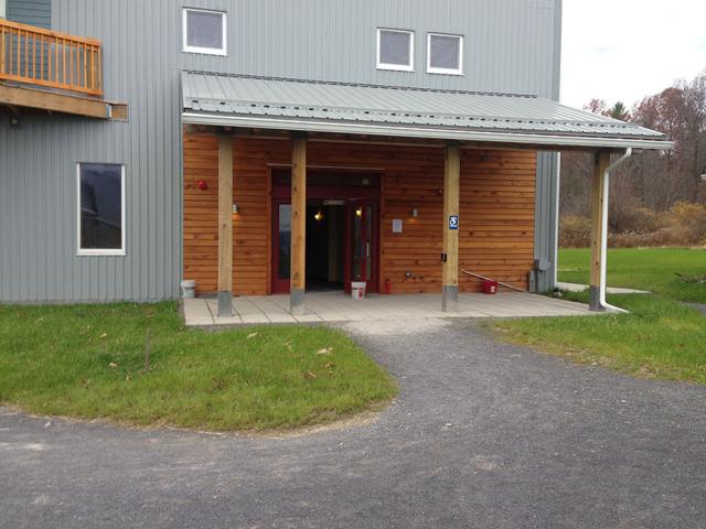 Durable fiber cement, stained wood, and 29-gauge metal siding; metal roofing; covered entries; triple-pane windows; and earthquake strapping all add to the storm resistance of this multifamily building in upstate New York.