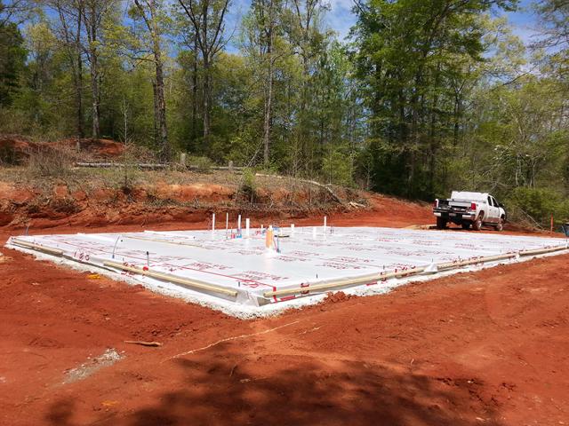 The builder employed good water management practices (like grading the surface away from the structure, pouring on a bed of gravel, and using a vapor barrier to prevent moisture from wicking up into the walls) to help keep the uninsulated monolithic slab-on-grade foundation dry.