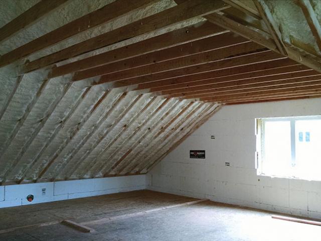 A hybrid application of 11 inches of open-cell spray foam and 2 inches of closed-cell spray foam create a conditioned attic that ties into insulated concrete forms to provide a continuous thermal blanket around the structure.