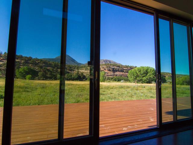 Passive solar design features, such as extensive south-facing windows and exposed concrete slab flooring to absorb winter sun, take advantage of free passive solar heating, while overhangs block high summer sun.