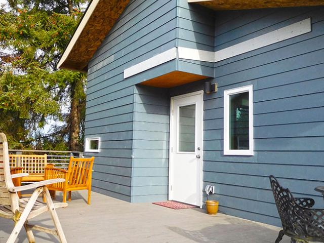 The walls of this house are constructed using 6-inch structurally insulated panels with an insulation value of R-29. The seams of the panels are taped, and the cement board siding is caulked at all seams to prevent air leaks.