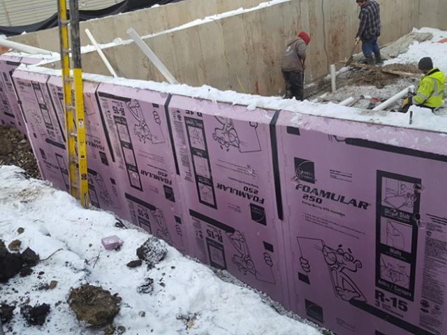 The basement walls are wrapped with 3 inches of XPS rigid foam that will be taped at the seams then covered with a dimpled plastic water barrier. The basement walls extend 3 feet above grade providing basement rooms with daylight through 24-inch-tall above-grade windows.