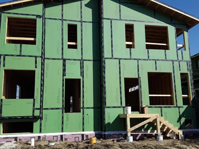 A coated OSB sheathing product covers the walls. When the seams are taped, the sheathing serves as a weather-resistant barrier as well as an air barrier so no house wrap is needed.