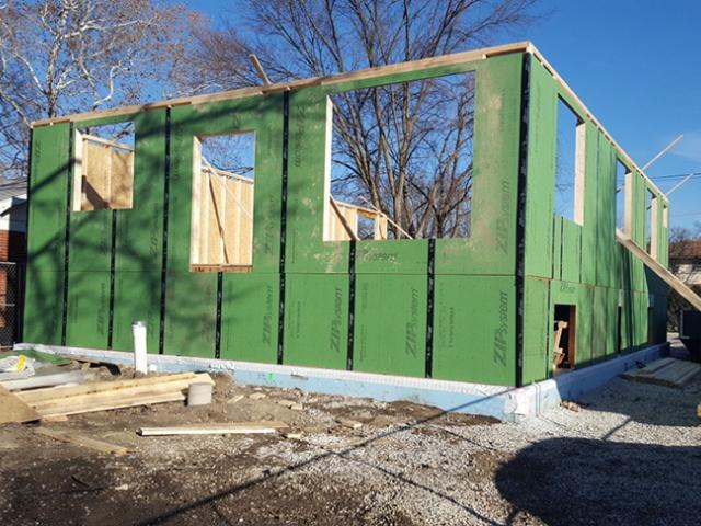 A coated OSB product with taped seams covers the walls to serve as both sheathing and weather-resistant barrier.