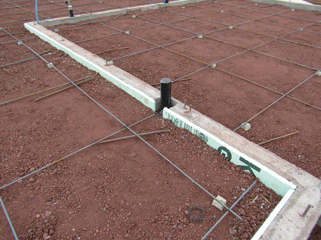 Two inches (R-10) of rigid foam lined the interior of the perimeter footing walls before the post-tensioned slab was poured.