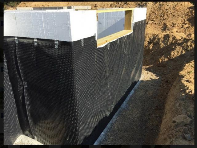 A dimpled plastic water barrier protects the insulated concrete form basement walls.