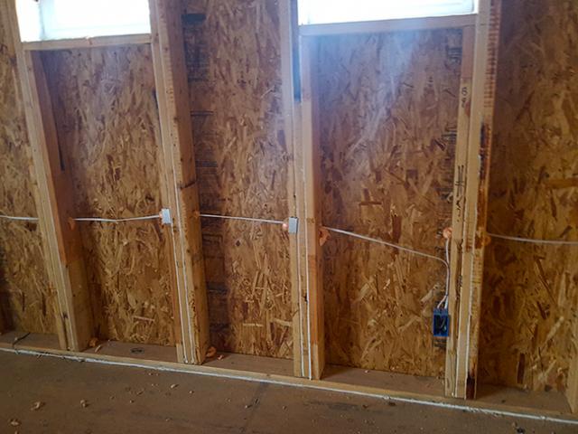Beads of caulk along the studs and sill plate help seal out drafts and bugs.