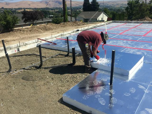 The concrete slab is surrounded by an ICF foundation wall and sits on a 5-inch-thick layer of reclaimed foil-faced EPS foam that was air-sealed with a durable tape to form an air, moisture, radon, and thermal barrier beneath the slab.