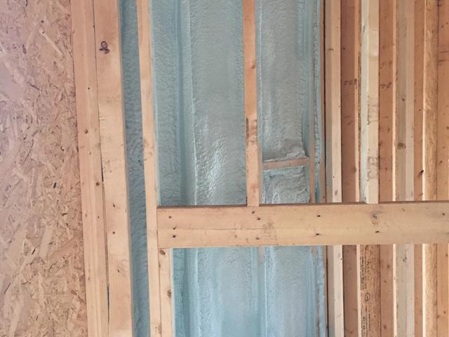 Spray foam insulates and air-seals the exterior wall behind the fireplace.