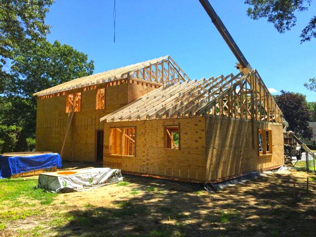 The walls are advance framed with 2-by-6s at 24-inch on-center and sheathed with 5/8-inch cdx plywood. Over the sheathing the builders installed house wrap, then two layers of ¾-inch polyiso rigid insulation with staggered and taped seams. Furring strips were applied to provide a drainage gap between the rigid insulation and the vinyl siding.