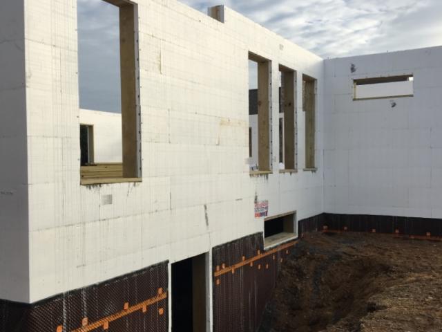 A dimpled plastic drain mat wraps the below-grade ICF walls to help prevent frost damage.