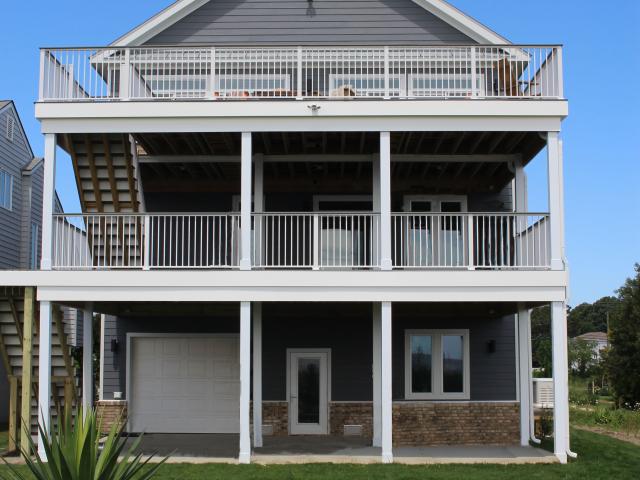 The lower half of the ground-floor walls of this coastal home consist of foam-filled concrete block, while the upper half and second and third floors are 2-by-6 stud-framed walls covered with an R-3.6-insulated coated OSB sheathing product taped at the seams for water and wind resistance. On the north and east sides of the home, house wrap is added as a second layer of protection against severe storms. The walls are then covered with a durable fiber cement siding.