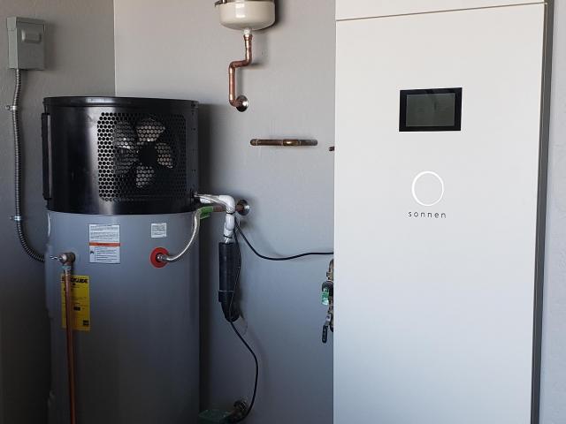 The high-efficiency heat pump water heater, located next to the PV power storage battery, helps cool the garage while efficiently heating the home's water supply.